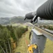 ndustriekletterer führt gesicherte Wartungsarbeiten an einer Beschneiungsanlage im Skigebiet durch und ist mit Seiltechnik am Mast positioniert